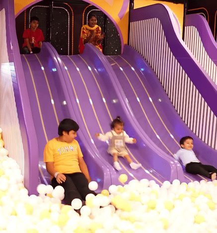 Children enjoying colourful slides and a ball pit in the soft play area at Wooray Hyderabad.