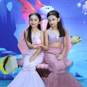 Two children dressed as mermaids enjoying an underwater-themed experience at Wooray Hyderabad.