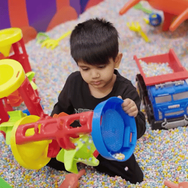 Child enjoying colourful sensory ball pit play with toys at Wooray Hyderabad.