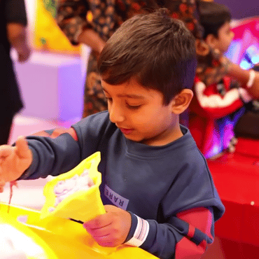 Child enjoying a colourful hands-on creative activity at Wooray Hyderabad play area.