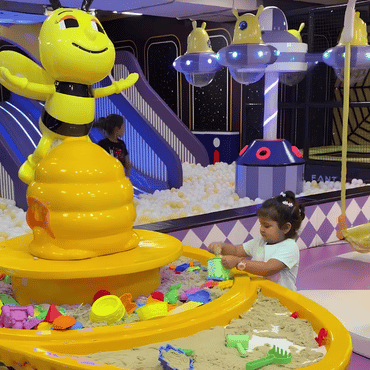 Child enjoying colourful sensory sand and water play at Wooray Hyderabad indoor play area.